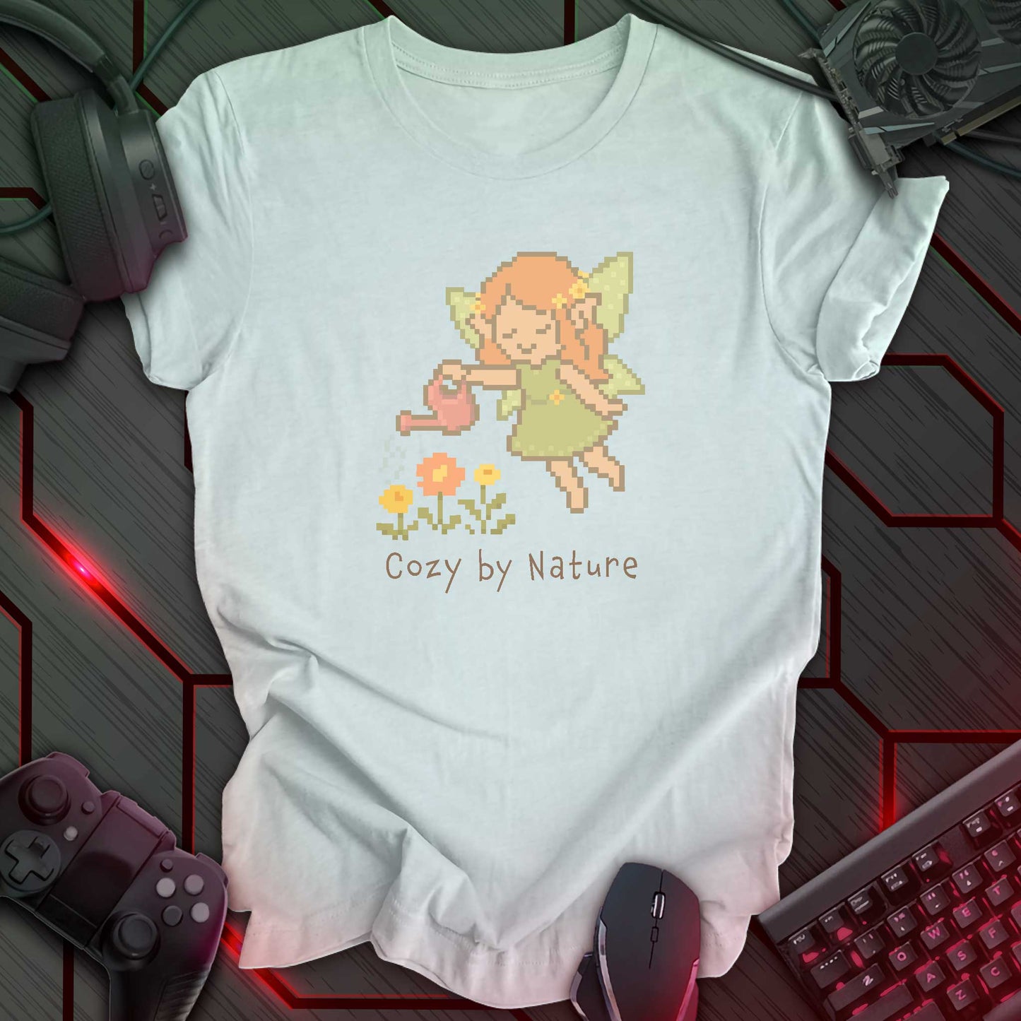 Pixel art fairy with leafy wings watering flowers using a pink watering can, above the text "Cozy by Nature" in cozy kawaii gamer style. Heather Ice Blue background.