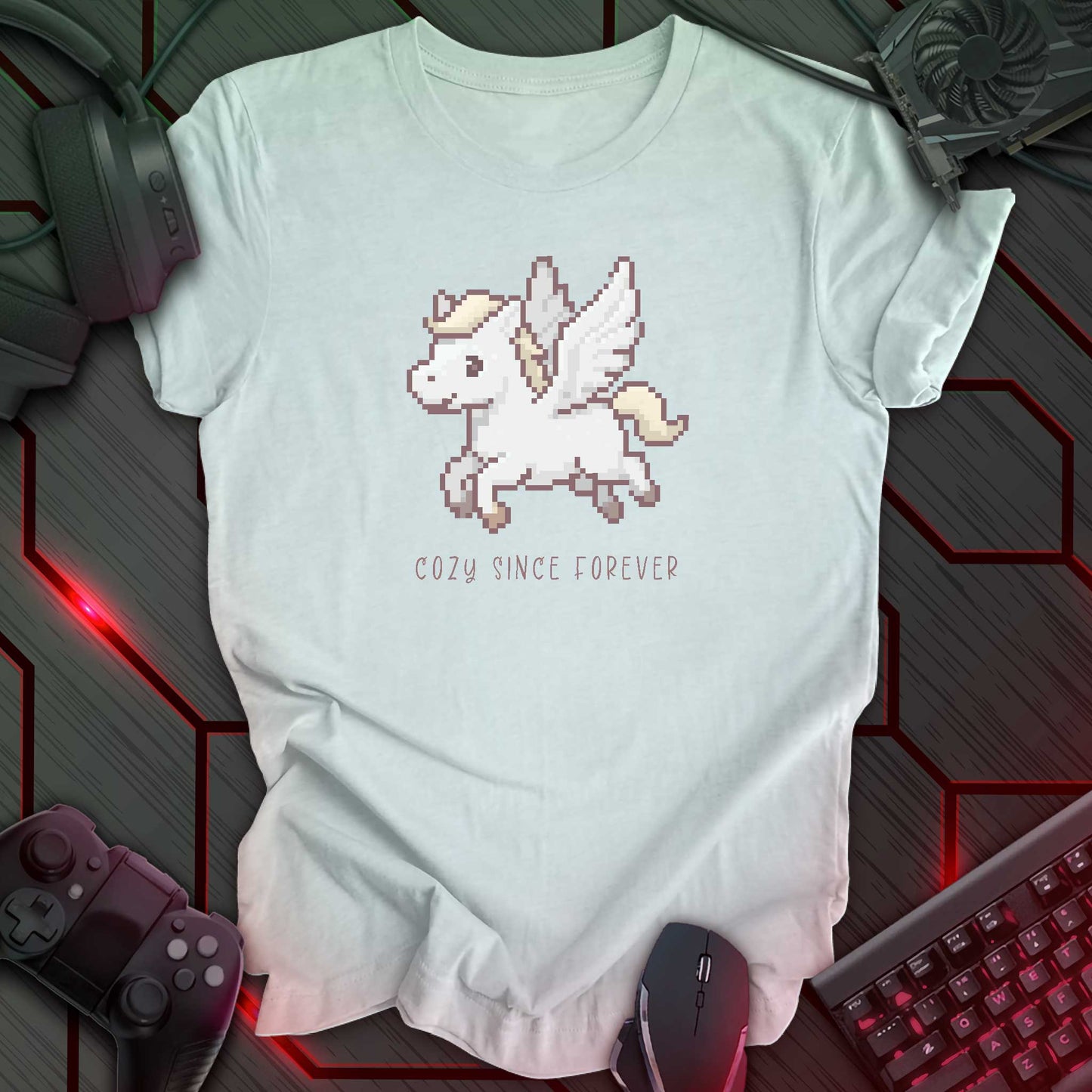 light blue t-shirt with a chest print of a pixel art cute winged Pegasus flying about handwritten styled text that reads "COZY SINCE FOREVER".