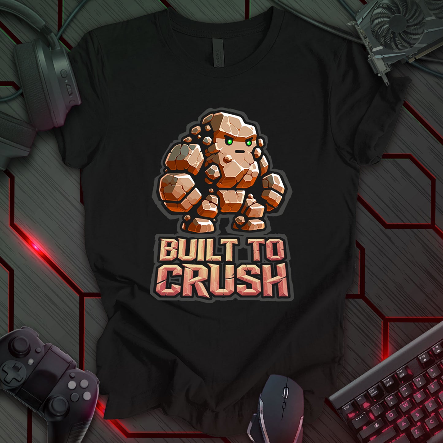 Black gaming t-shirt featuring a cartoon-style rock monster composed of chunky boulder shapes with large arms, legs, and bright green eyes. Below the rock monster, bold stone-text reads 'BUILT TO CRUSH,' designed in a rugged, carved stone font.