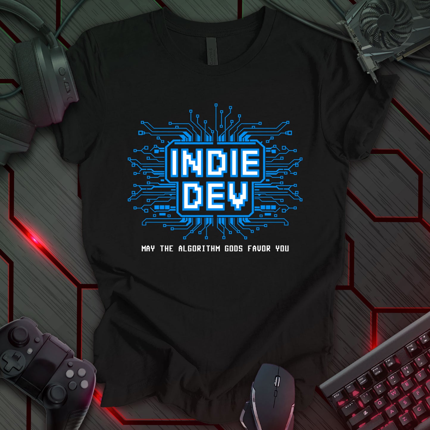 T-shirt design with pixelated text "INDIE DEV" in a blue frame, surrounded by a circuit board pattern on a black background. Includes "MAY THE ALGORITHM GODS FAVOR YOU" below. Design for indie game developers and programmers. Keywords: indie dev shirt, game developer tee, coding t-shirt, programmer apparel, pixel art design, computer science gift, software engineer clothing, tech humor shirt.