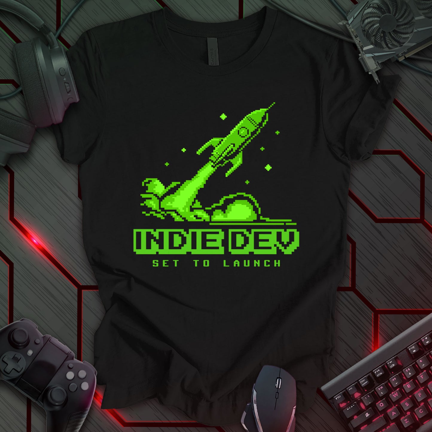 This t-shirt design, aimed at indie game developers, features a pixel art green rocket launching upwards on a black background. The text 'INDIE DEV' is displayed below the rocket in pixelated font, with the phrase 'SET TO LAUNCH' underneath. It's a design that resonates with the excitement of releasing an independent game.