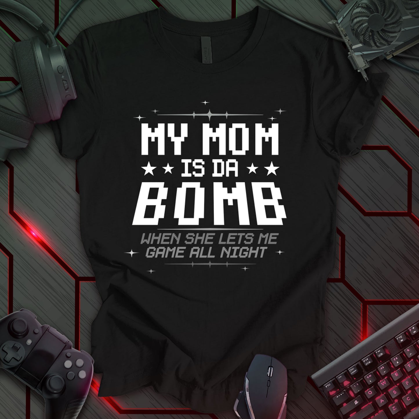 T-shirt design with pixelated white text "MY MOM ★ ★ IS DA ★ ★ BOMB" and "WHEN SHE LETS ME GAME ALL NIGHT" on a black background. Humorous gamer t-shirt for kids or teens who love gaming. Great for casual wear or gifts. Keywords: gamer mom shirt, funny kid tee, video game t-shirt, pixel art clothing, gaming humor, teen gamer gift, mom appreciation shirt.