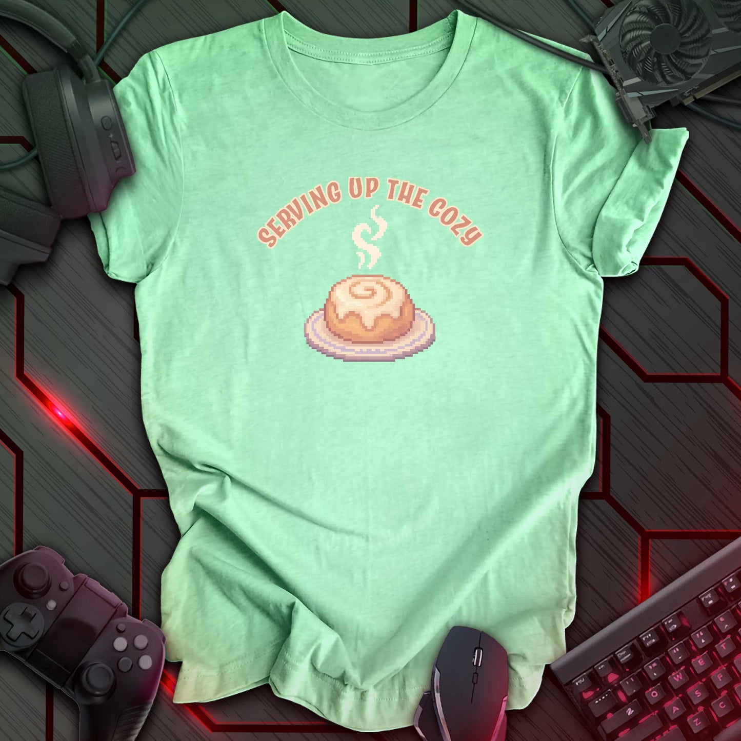 Pixel art cinnamon roll with steam on a plate under text “Serving Up the Cozy” in cozy gamer kawaii style. Heather Mint background.