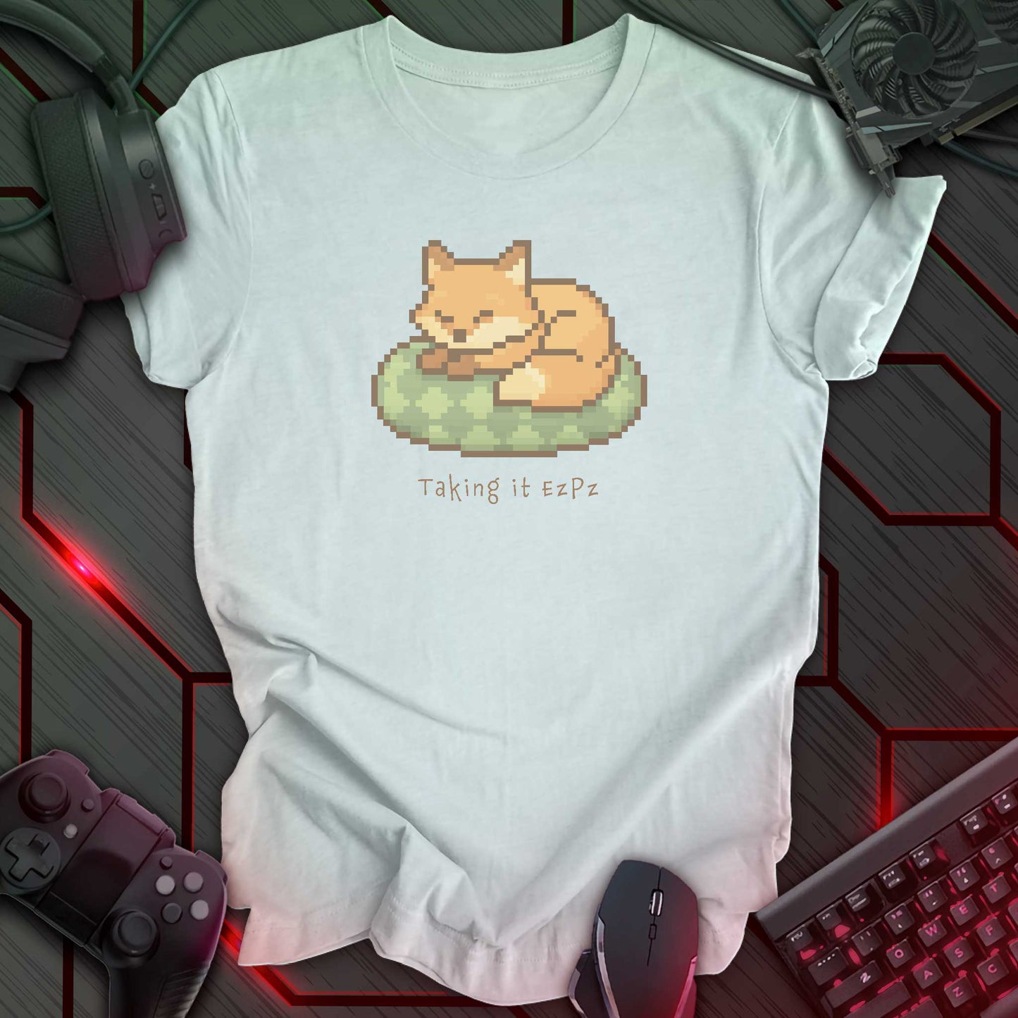 Pixel art sleeping fox curled on a green cushion above the phrase "Taking it EzPz" in cozy kawaii gamer style. Heather Ice Blue background.
