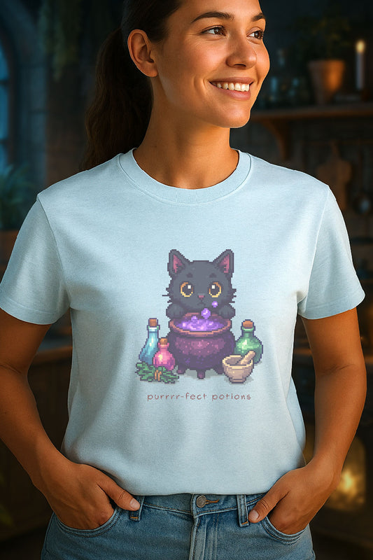 Young woman wearing a light blue t-shirt with a design of a pixel art black cat brewing purple potion in cauldron with bottles, herbs, and text “Purrrr-fect Potions.” 