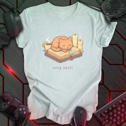 Pixel art orange cat sleeping on a book with candles and a coffee mug, under the text "cozy spell" in soft cozy gamer style. Heather Ice Blue background.