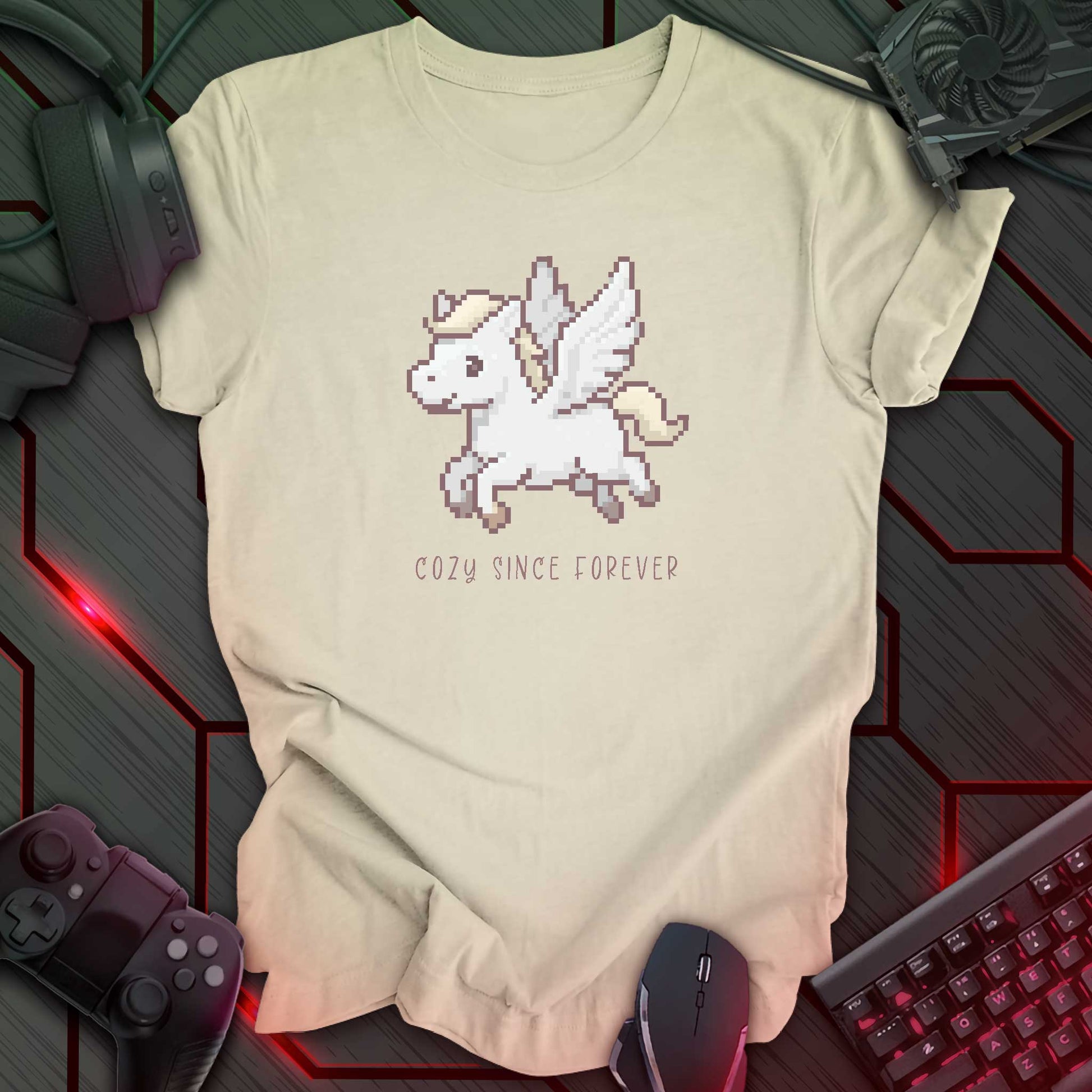 natural color t-shirt with a chest print of a pixel art cute winged Pegasus flying about handwritten styled  text that reads "COZY SINCE FOREVER". 