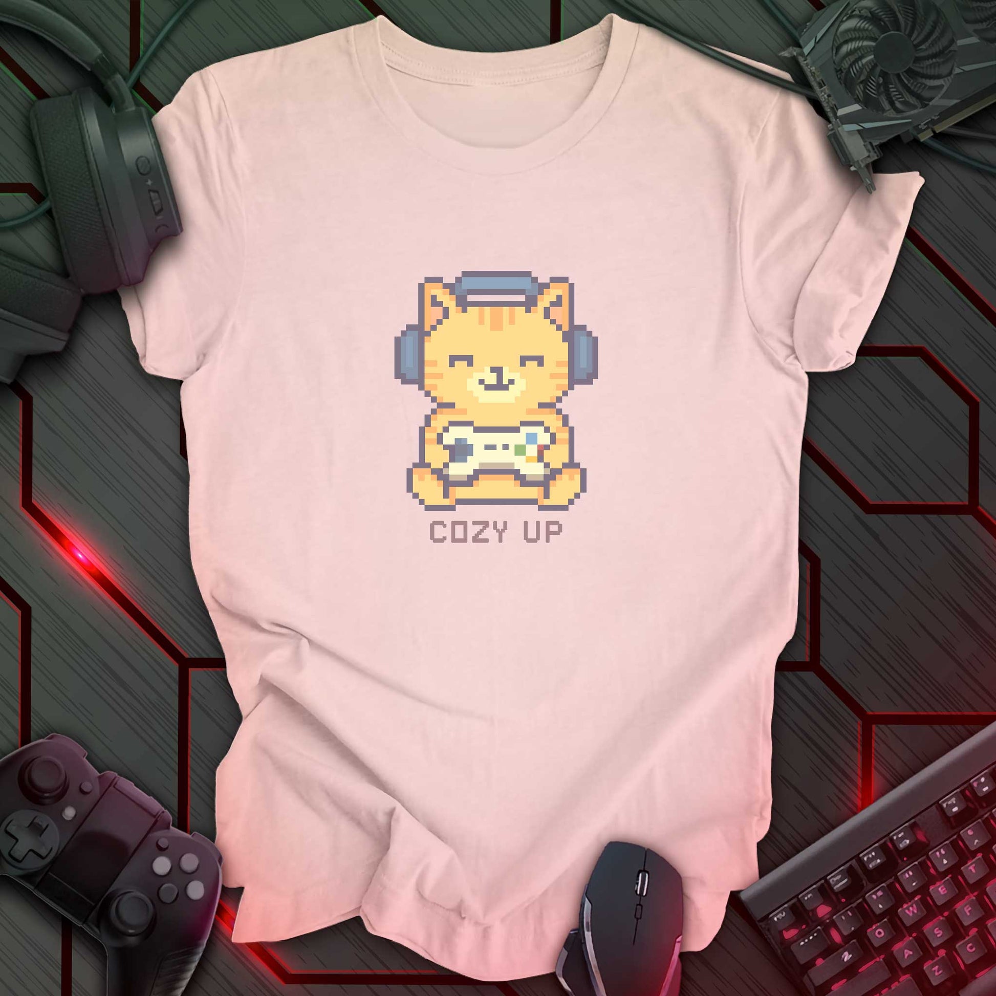 Pixel art orange cat wearing headphones and holding a game controller above the words "Cozy Up" in cozy gamer kawaii style. Soft Pink background.