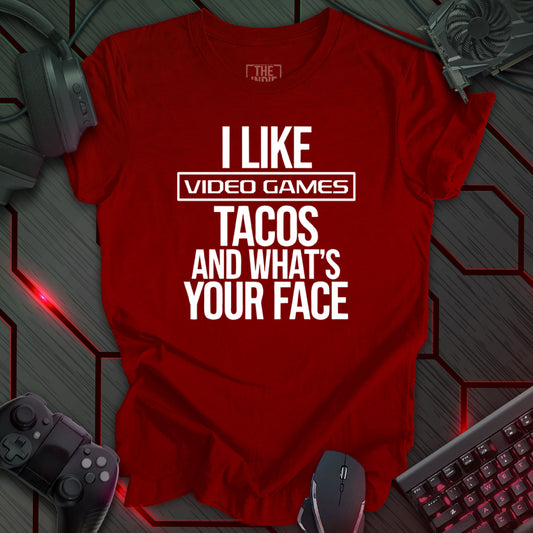 Graphic design featuring the phrase 'I LIKE' in a bold, slightly distressed font at the top, followed by 'VIDEO GAMES' with a rectangle boarder, 'TACOS', and 'AND WHAT'S YOUR FACE' each on separate lines in the same bold, distressed font. All text is white against a cardinal red background. This is a humorous design with an indie gaming and food theme, featuring a playful and quirky sentiment.

