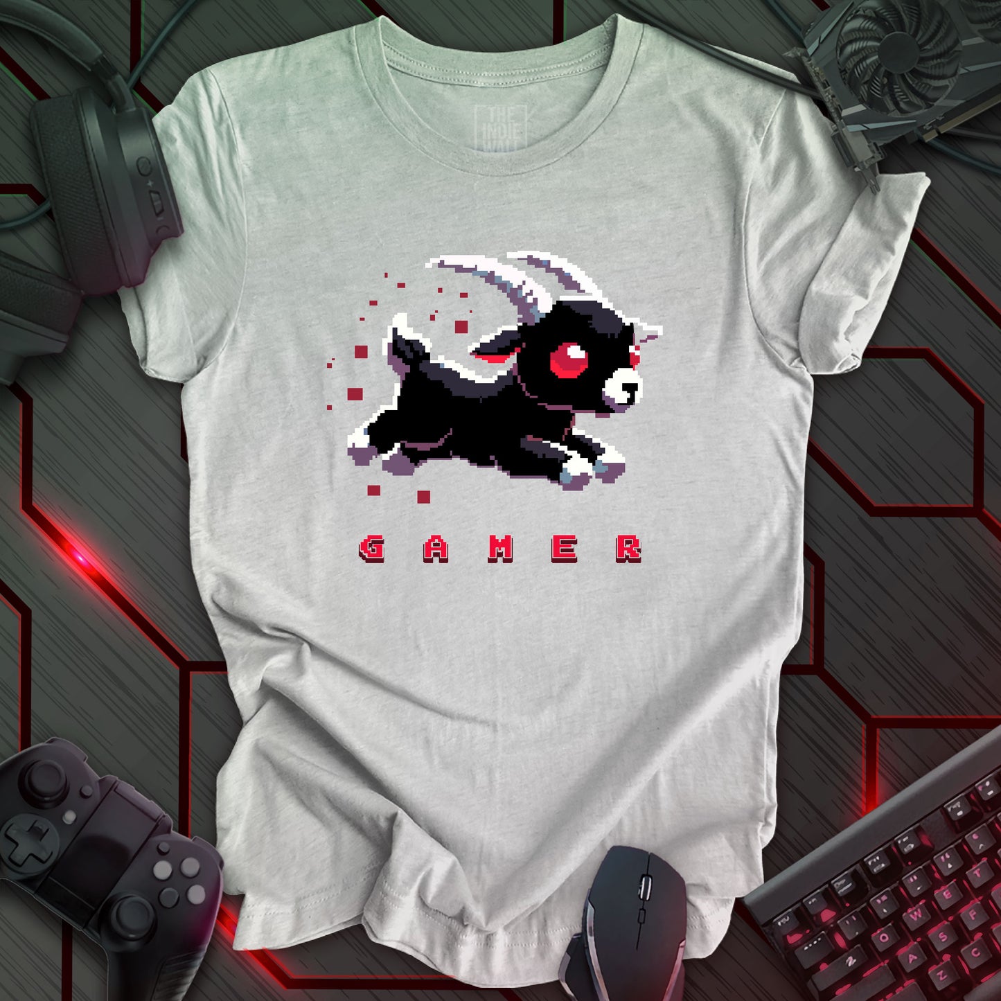 leaping pixel art black baby goat with large white horns, large red eyes trailed by red pixels. The single word "GAMER" written in a pixel art font beneath the image. Athletic grey background. 