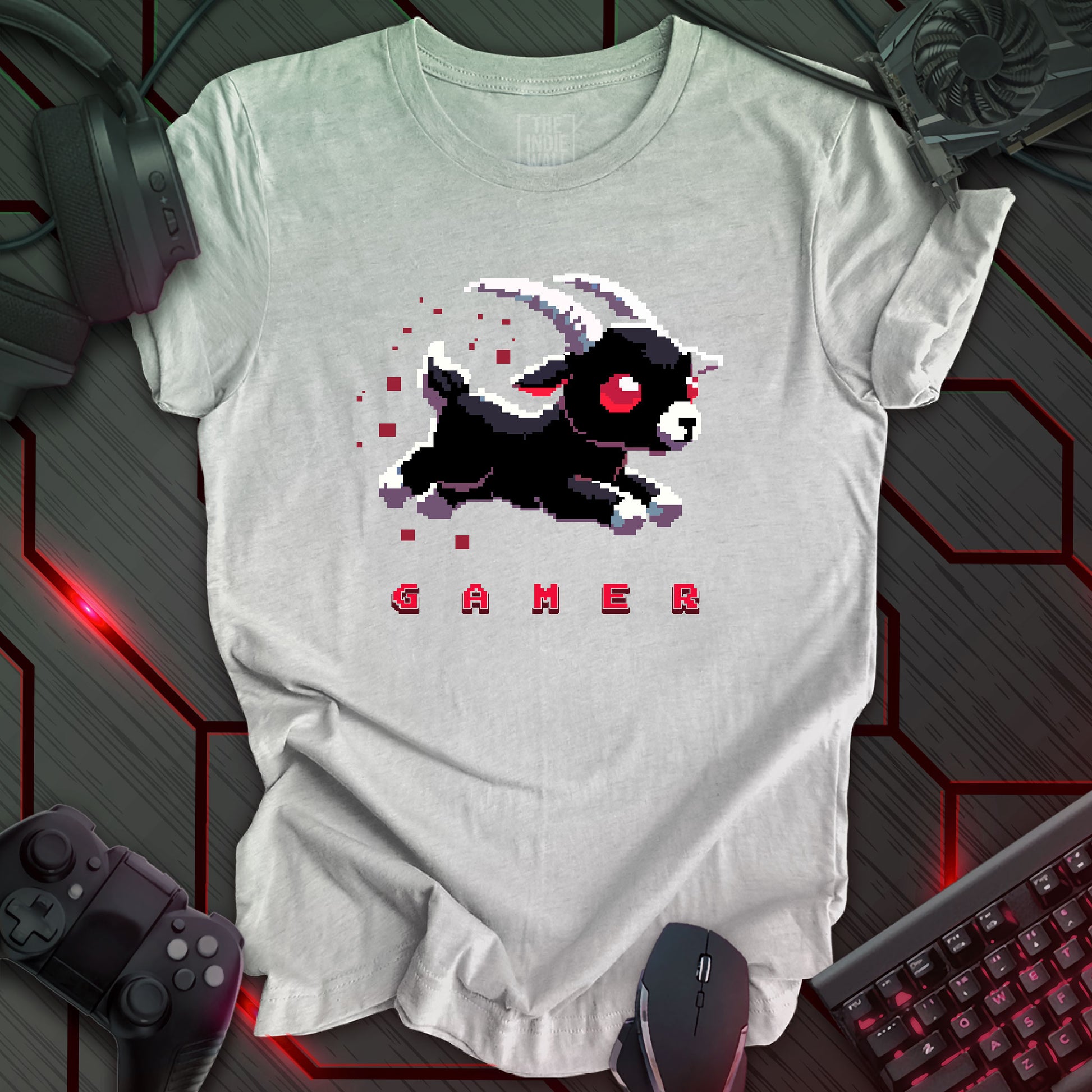 leaping pixel art black baby goat with large white horns, large red eyes trailed by red pixels. The single word "GAMER" written in a pixel art font beneath the image. Athletic grey background. 