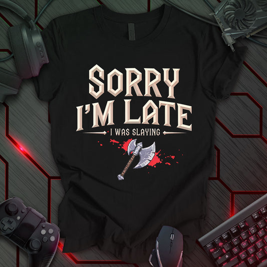 Graphic design featuring the phrase 'SORRY I'M LATE' in a bold, pixelated font at the top, followed by 'I WAS SLAYING' in a smaller pixelated font with decorative arrows on either side. Below the text is a pixel art illustration of a gray axe with a brown handle, resting on a red splatter against a black background. This is a humorous design with a fantasy gaming theme, featuring a pixel art axe and a relatable excuse.