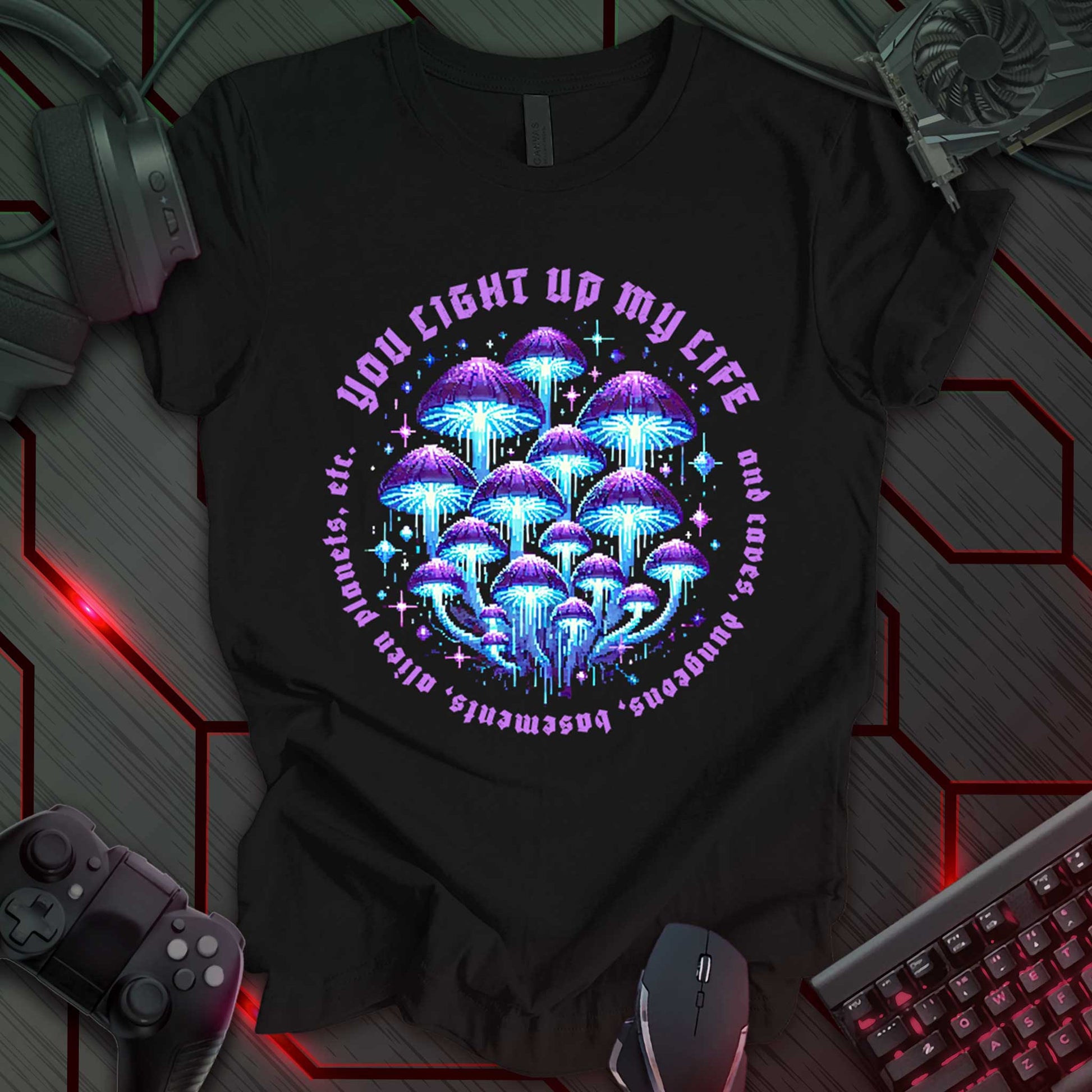Black T-shirt featuring a vibrant pixel-art design of glowing blue and purple mushrooms. Encircled by distressed gothic-style text that reads, 'YOU LIGHT UP MY LIFE and caves, dungeons, basements, alien planets, etc.' Perfect for fantasy lovers, gamers, and adventure enthusiasts.