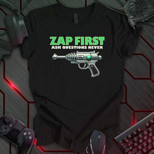 This t-shirt design, created for those with a humorous and rebellious spirit, features the phrase 'ZAP FIRST ASK QUESTIONS NEVER' in green, bold lettering above a detailed illustration of a vintage, silver ray gun on a black background. This design appeals to fans of retro science fiction and those who appreciate a bold, unconventional statement.